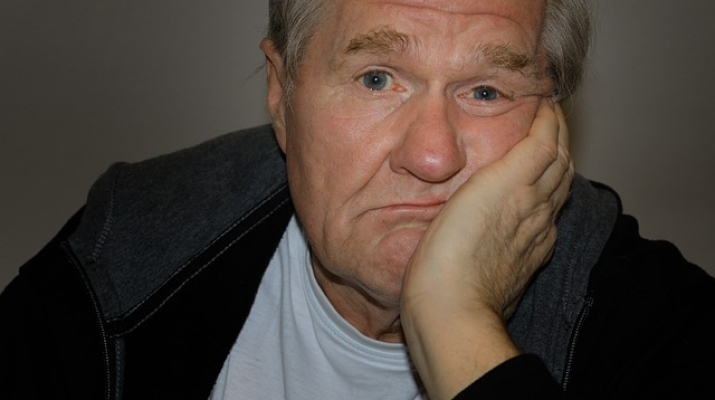 Older man with chin in his hand